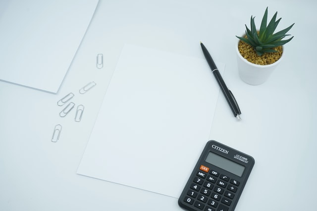 Working desk with calculator, pen, and smal plant