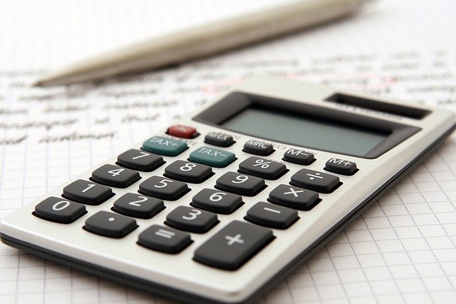 Calculator with a balance sheet and a pen out of focus