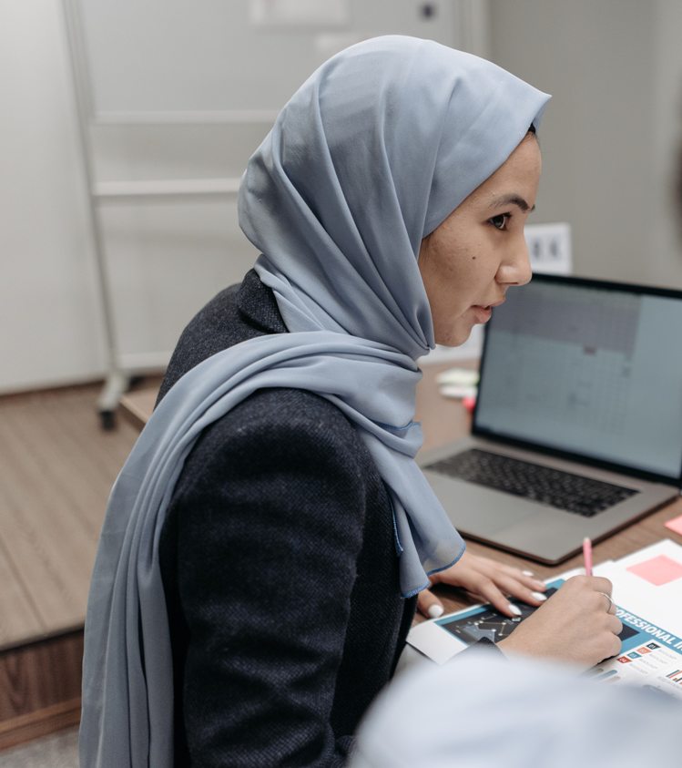 Woman in Gray Hijab Sitting Behind an Office Table