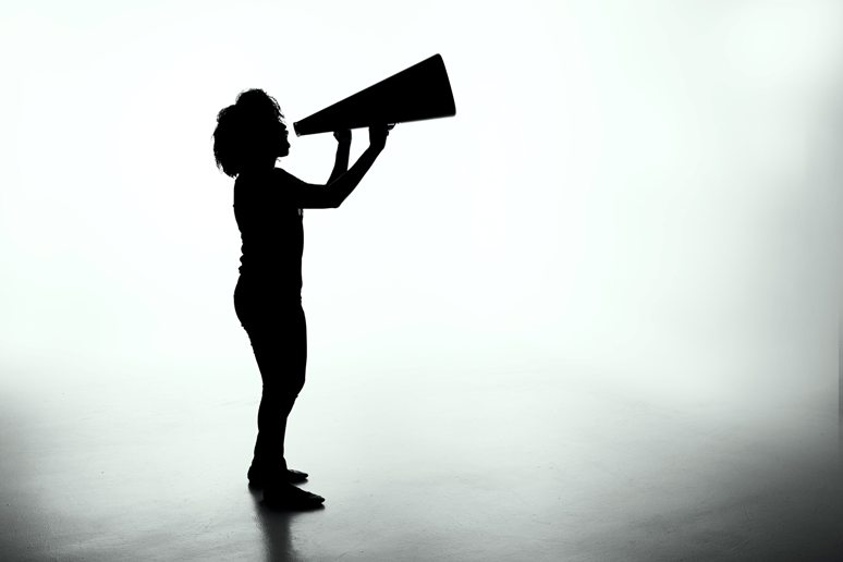 silhouette of woman speaking through a megaphone