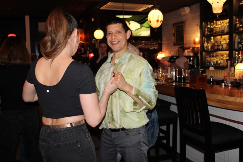 Alain Guillot dancing at a bar with a beautiful woman