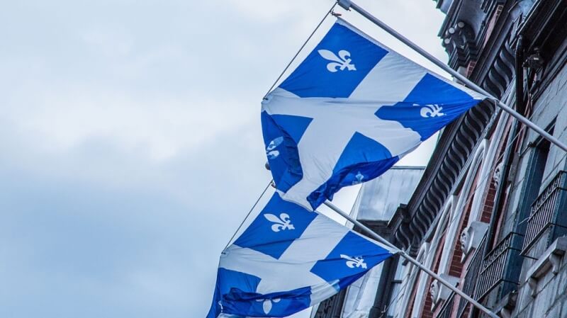 Flag of Quebec. Many immigrants feel the weight of racial discrimination